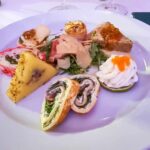 How Does A Romanian Wedding Menu Looks Like A white plate with a selection of appetisers on it.